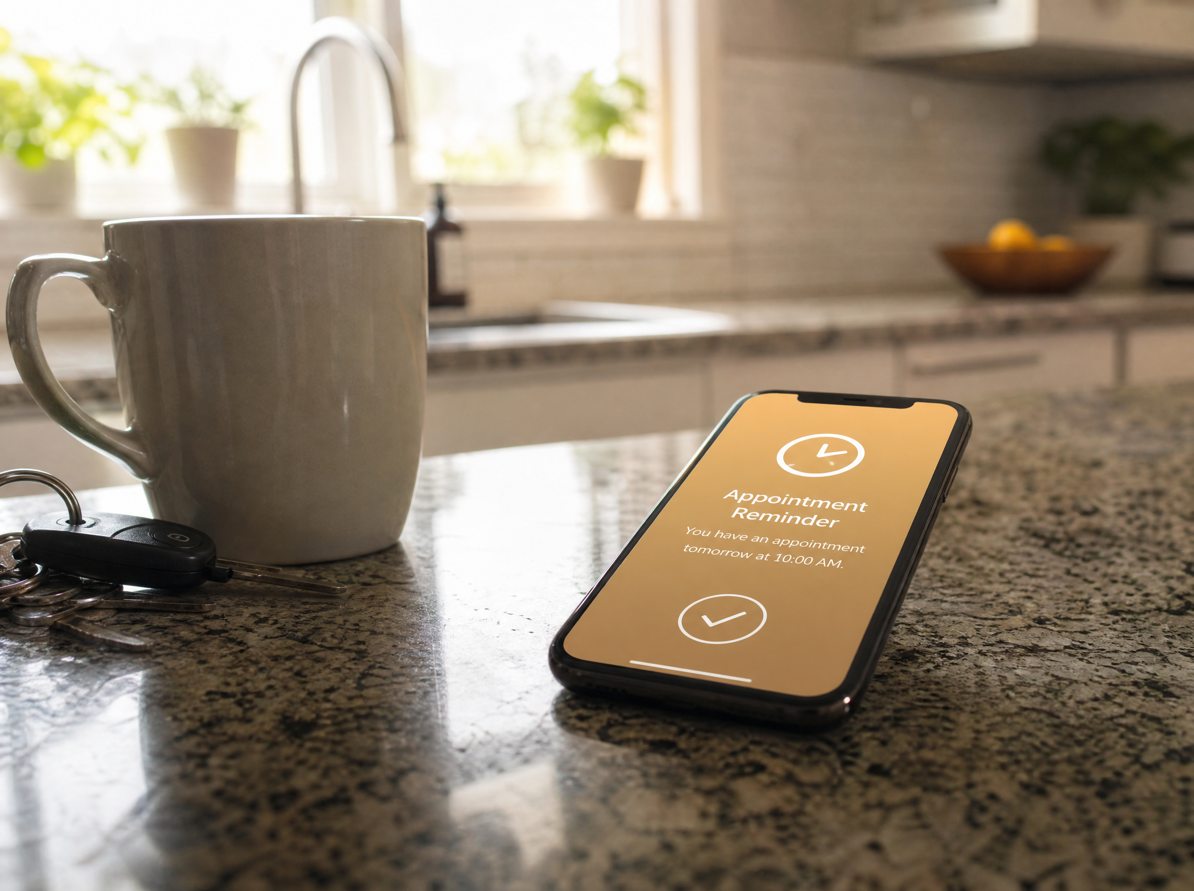 Smartphone lying face-up on a kitchen counter, screen glowing warm amber with a clock icon and checkmark showing an automatic appointment reminder text